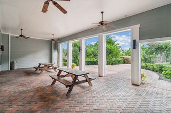 A patio with a table and chairs and a ceiling fan.